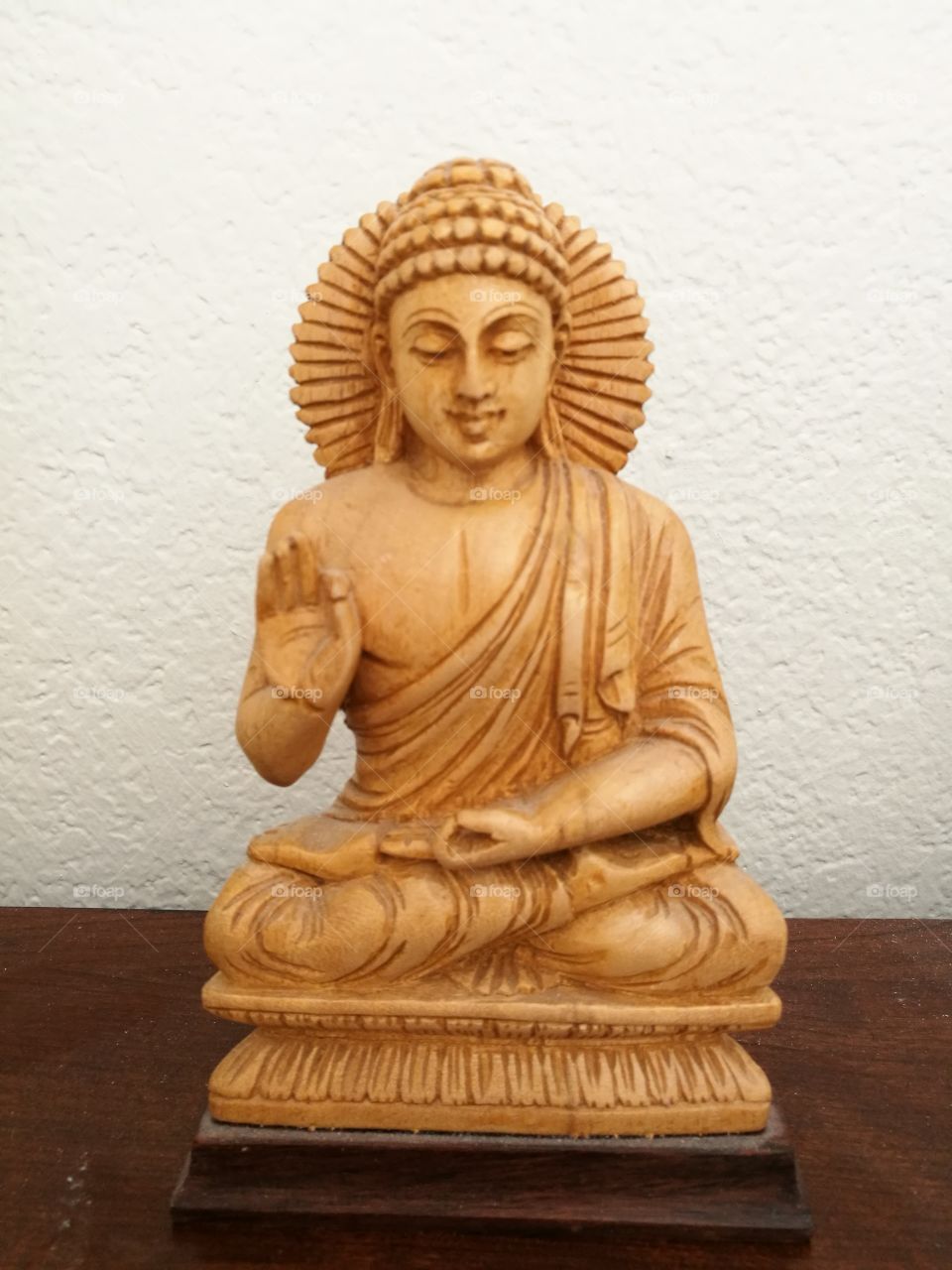 Japanese sitting Buddha statue on white wall background