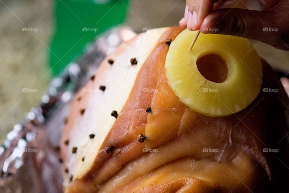 Woman putting cloves into Christmas Ham, preparing Christmas meal, Traditional Christmas dinner, dinner with family on Christmas, cooking at home, preparing meals in the kitchen, cloves used for cooking, Ham with cloves 