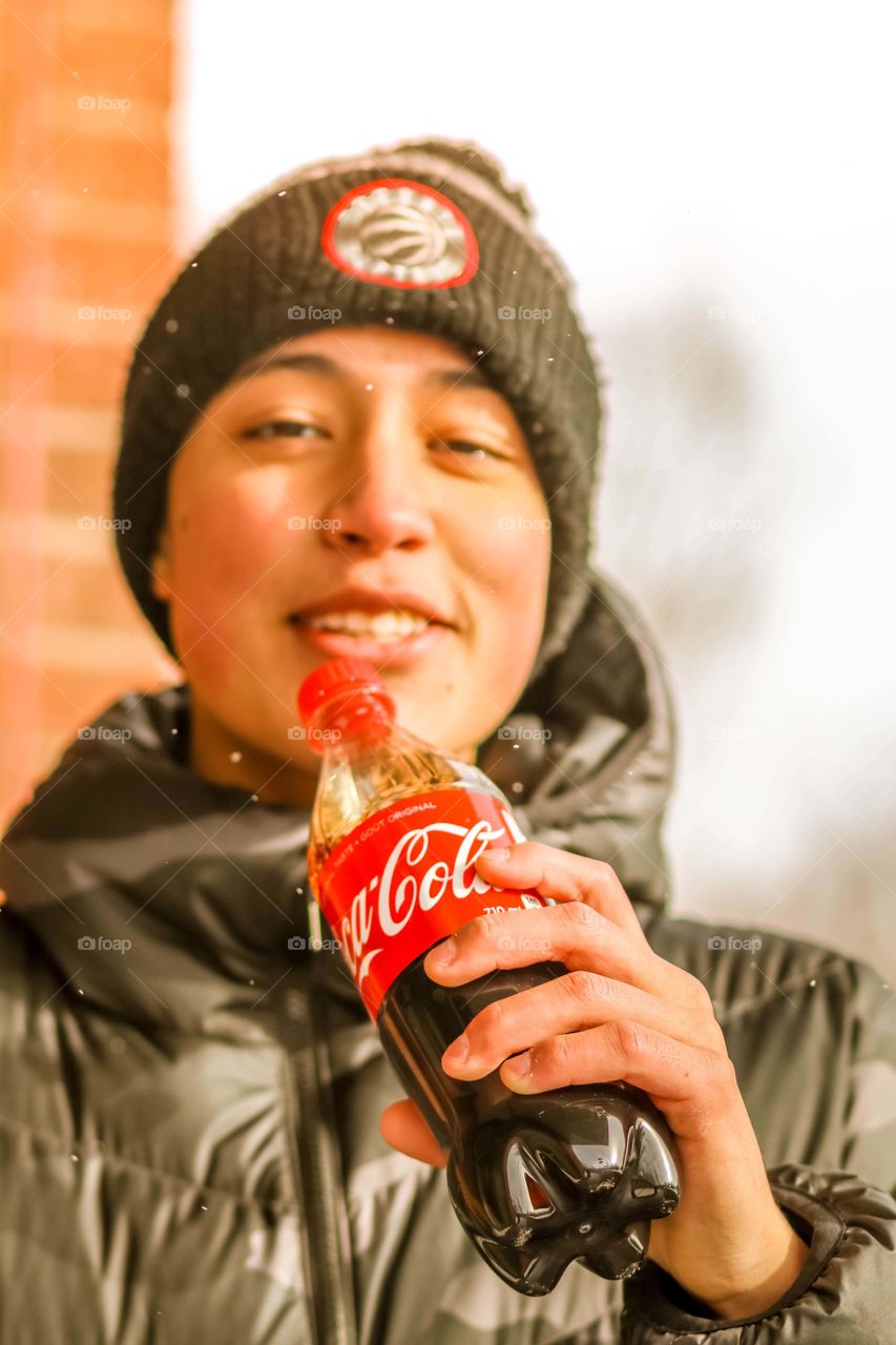 Happy teenager with a bottle of coca cola