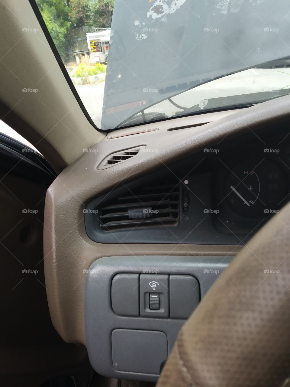 driver side of auto interior with hood up outside