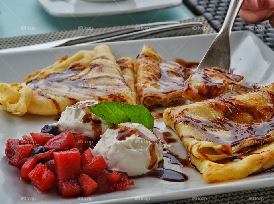 Gourmet Breakfast Crepes. Sweet Crepes covered With Brown Sugar With Rich Cream And Fruit
