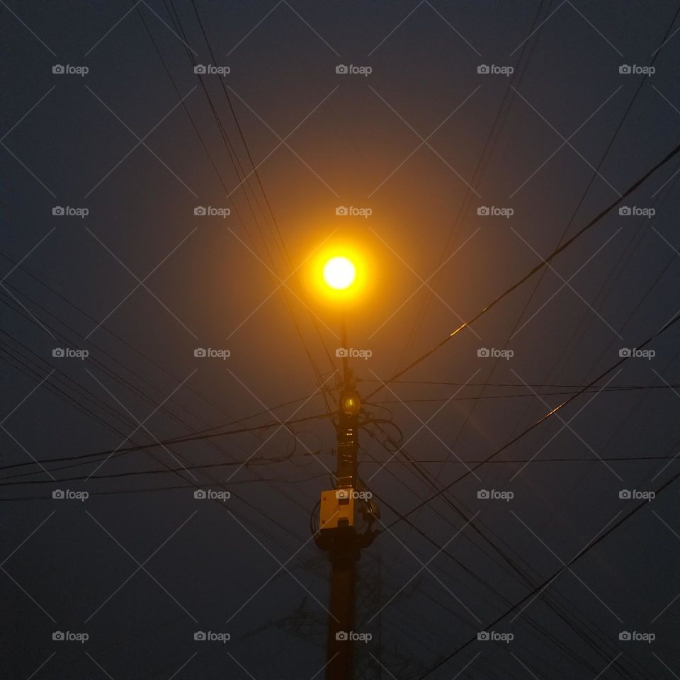 a round shape of a light in late evening and wires