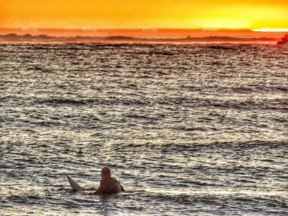 Surfing as the sun sets in Half Moon Bay, California