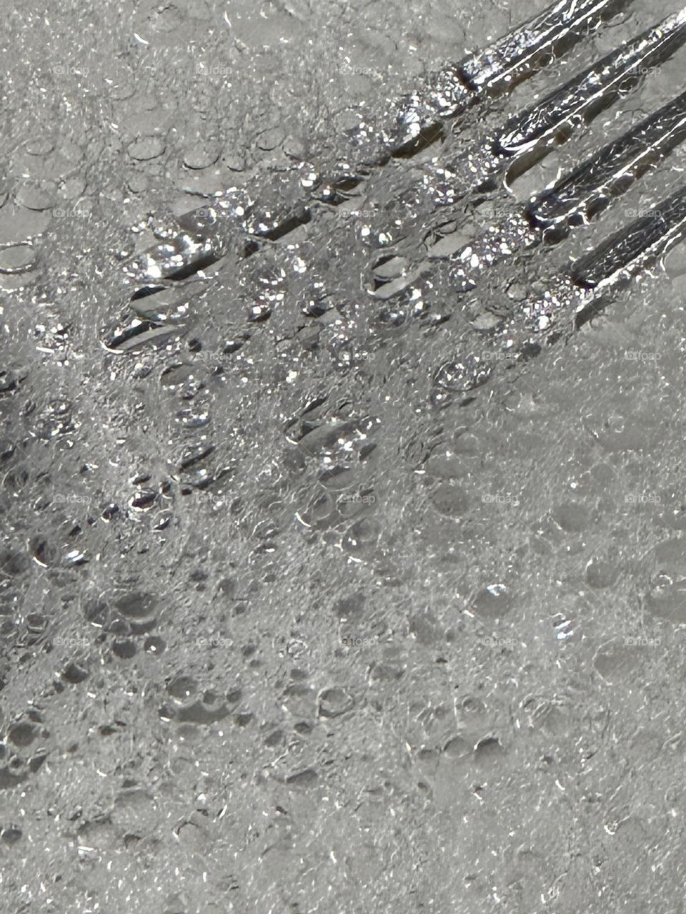 Close up of a stainless steel dinner fork in soap water