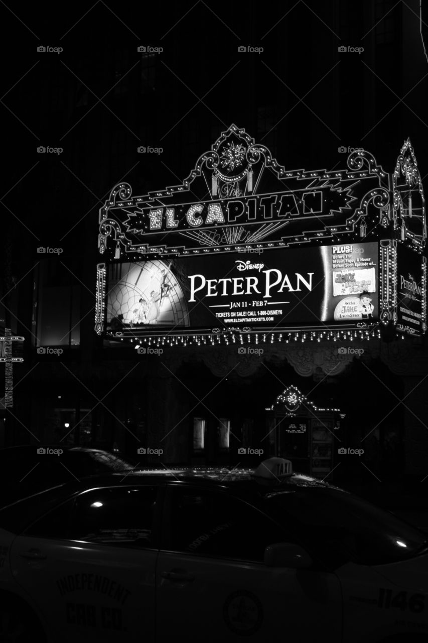 A half lit black and white photo from the front of the El Capitan theater. 2010 when Peter Pan was playing there. 