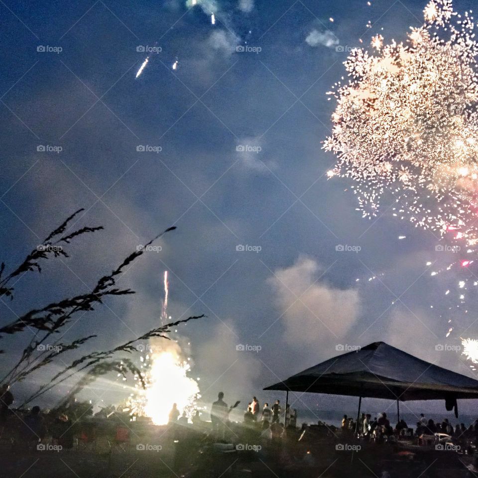 A festive 4th of July celebration on a private beach on the Puget Sound with dazzling fireworks exploding everywhere