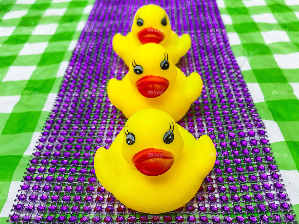 Clash of Colours: Three little yellow rubber duckies floating along on a purple gem lattice ‘river’ with a green plaid ‘riverbank’.
