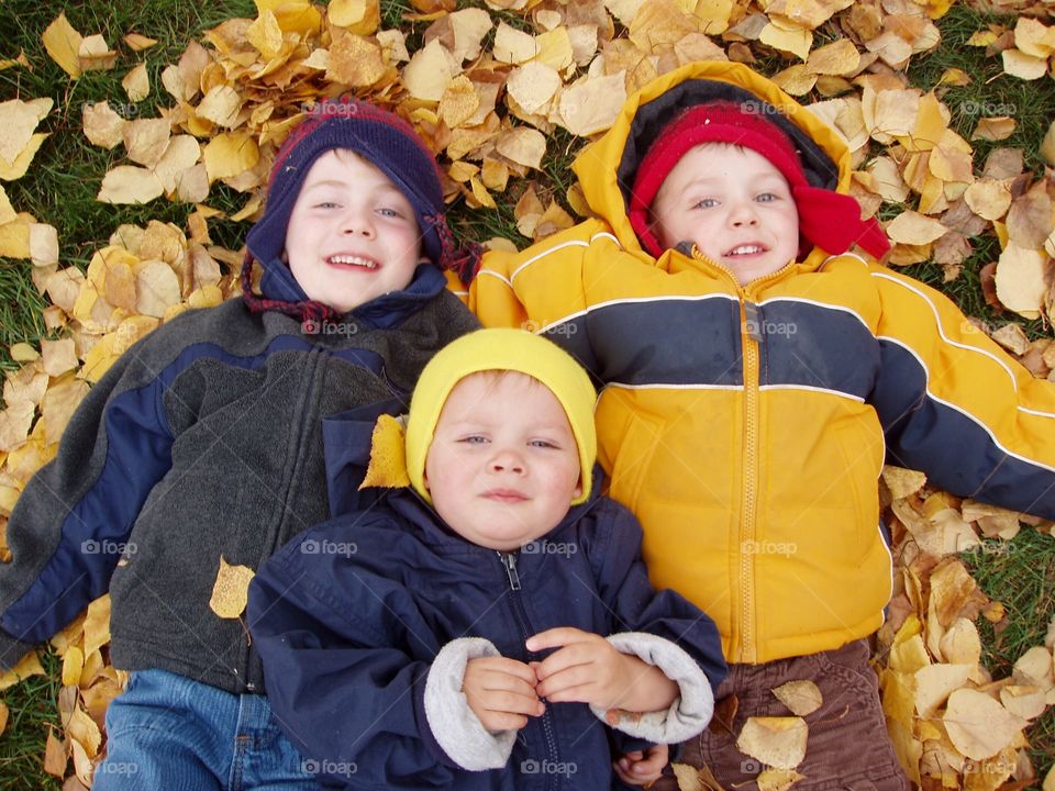 Brothers lying on dry autumn leaves