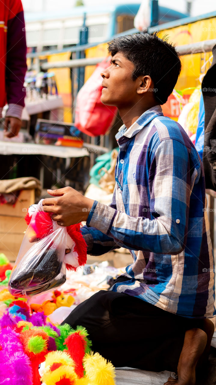 A little boy is selling some beautiful stuffs beside the Howrah Bridge in Kolkata. He is just 10 grade student & left his study to do business. He has to because he is the only source for his family.