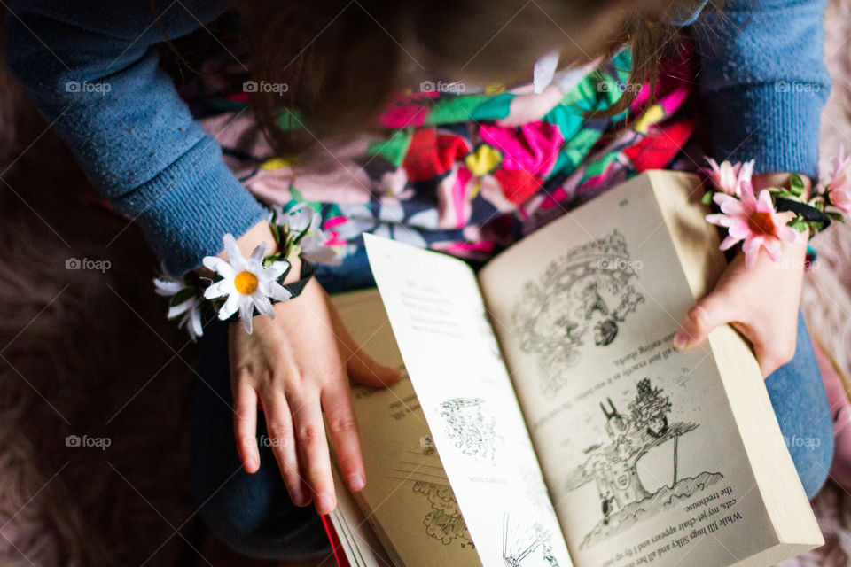 Summer memories my little girl loves dressing in bright flower clothes and reading books. Image of girl reading book