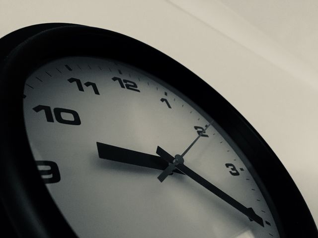 Monochrome image of a wall-mounted clock.