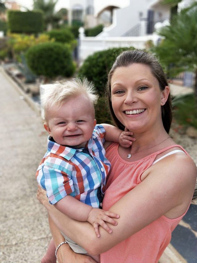 Woman holds her baby on a family holiday. 