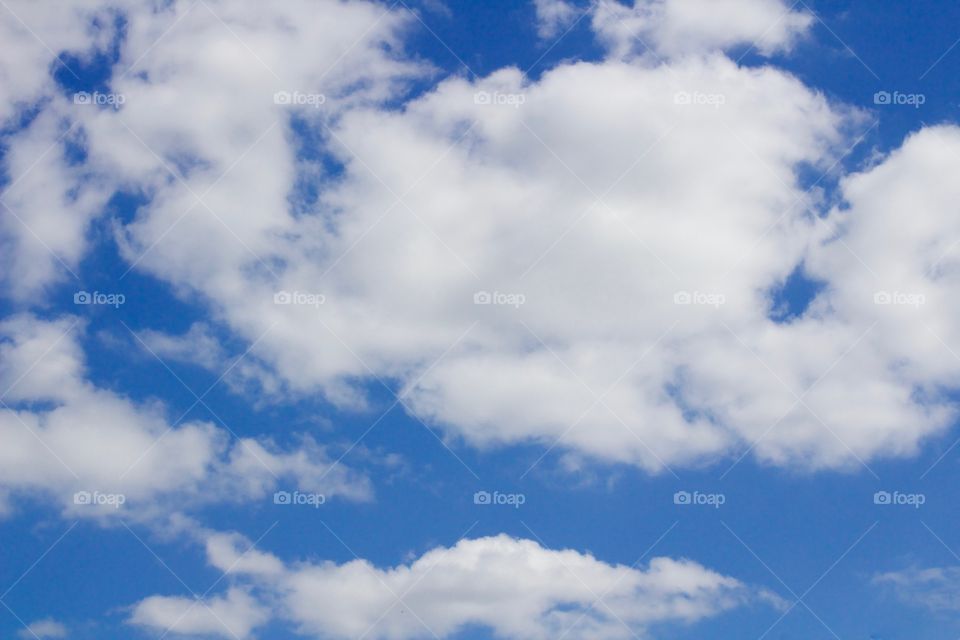 Puffy white clouds against a vivid blue sky