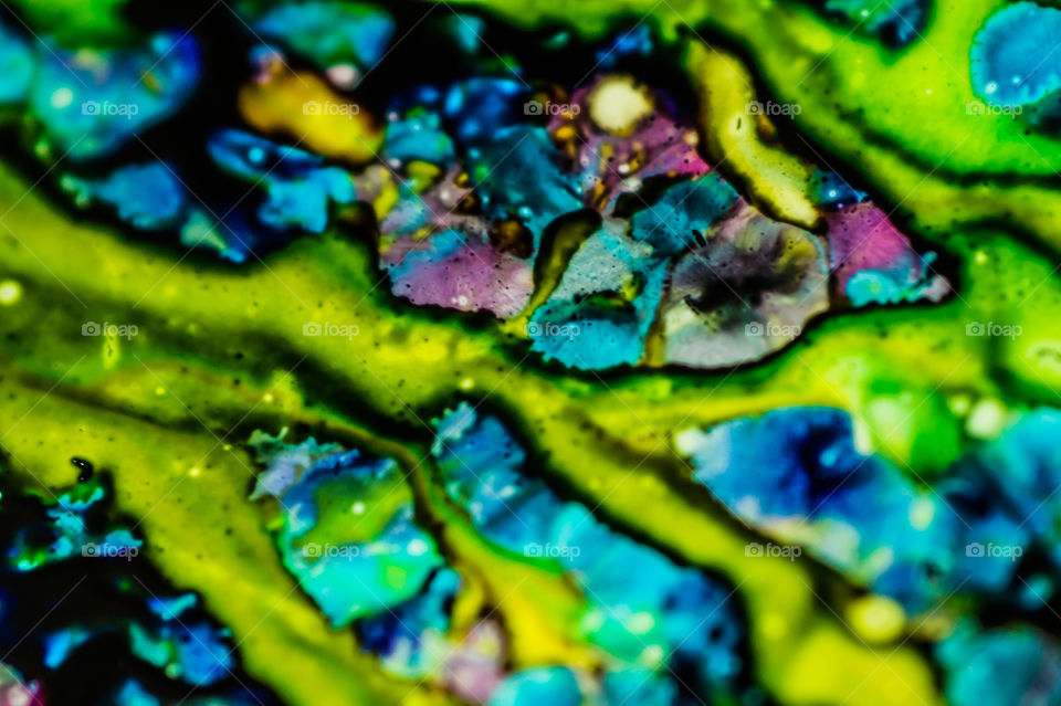 The ink to refill the printer cartridge was spilled onto the white washbasin and the paints blended into abstract drips and patterns