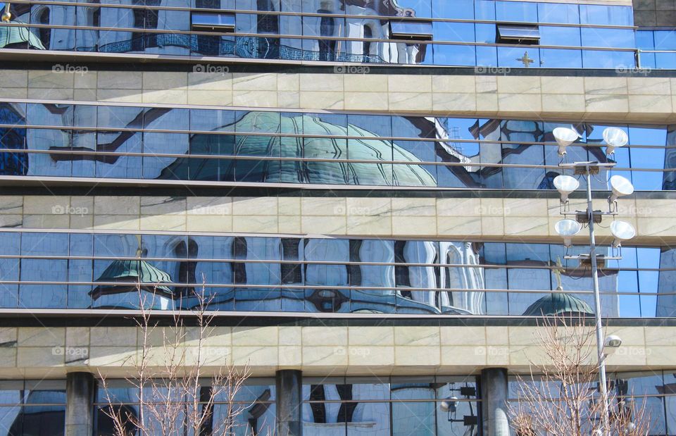 The reflection of the grandiose temple on the mirrored building