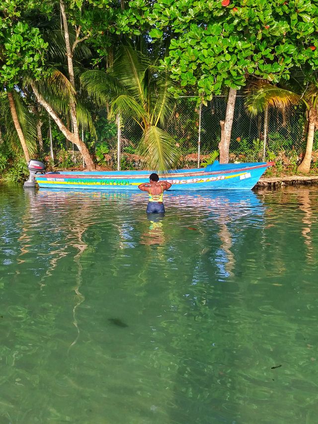 Young Woman Dressed in Blue and Yellow Bathsuit In river before a Blue and Yellow Boat