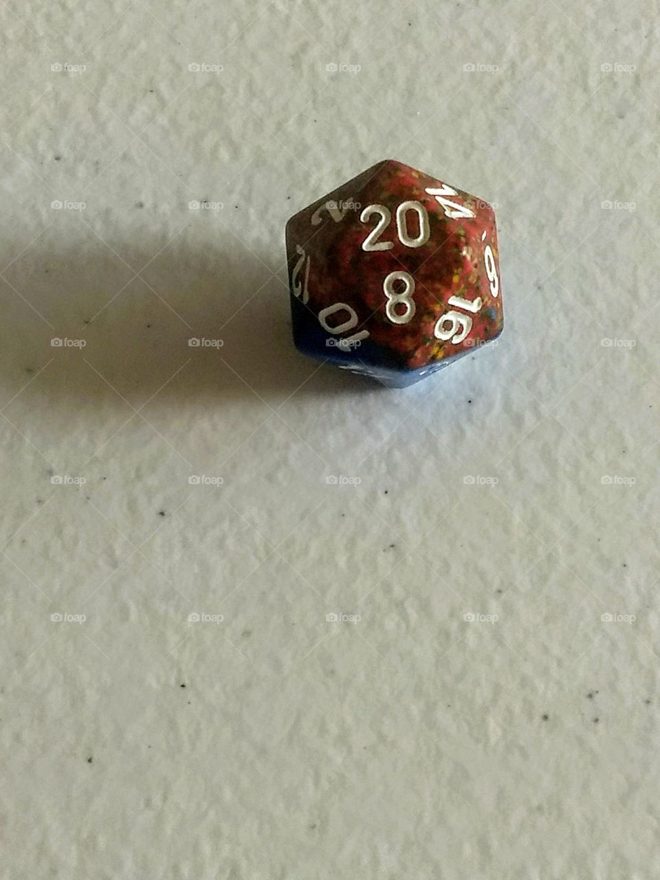 red twenty sided die used for tabletop role-playing games on white background