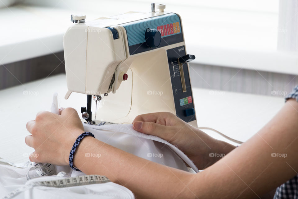 woman sews on the sewing machine