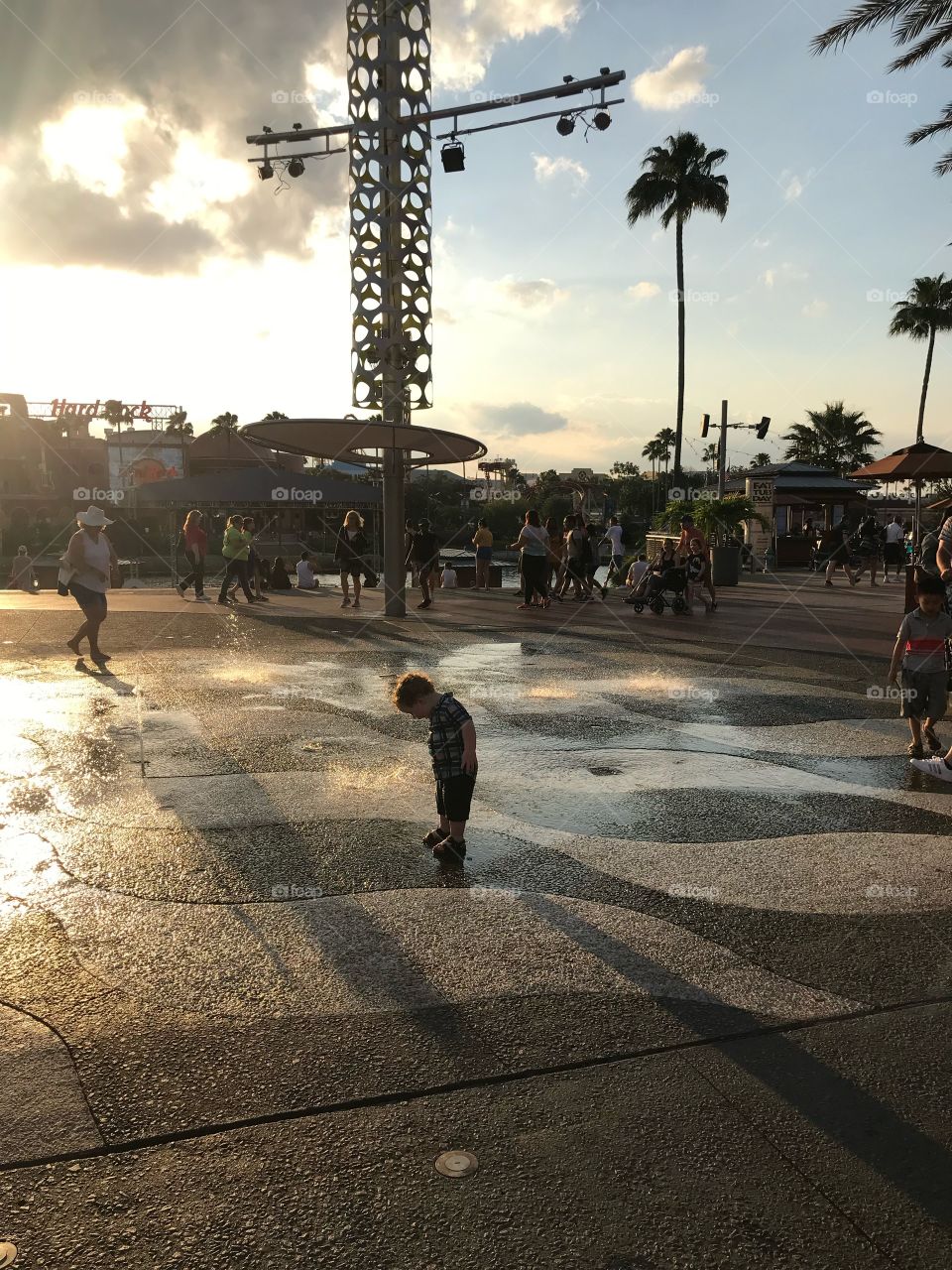 Child playing in water as sunset cast shadows