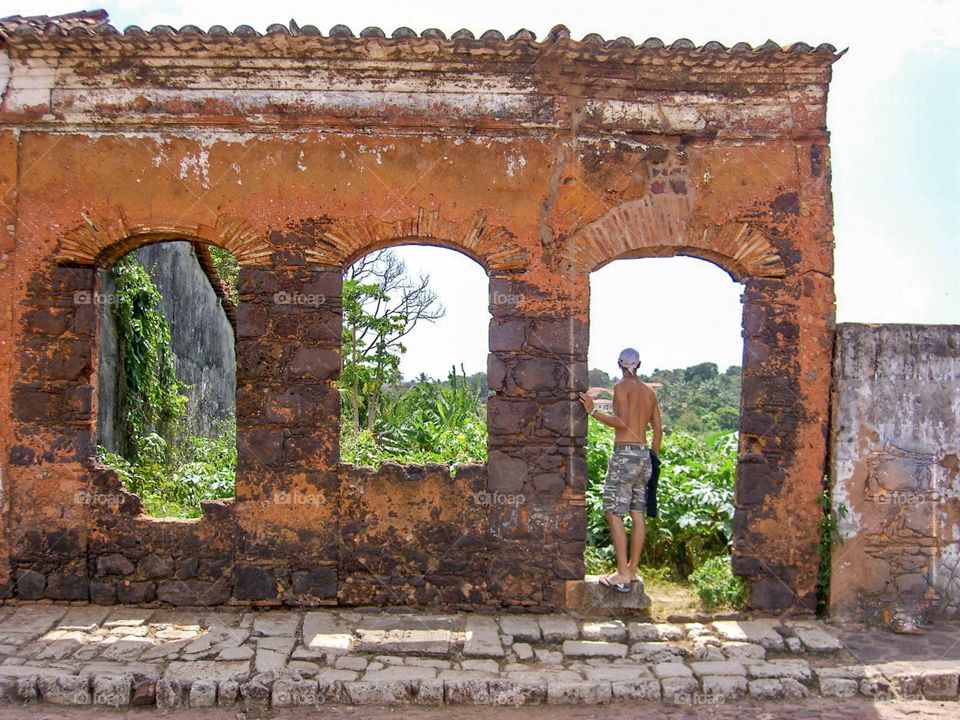 Three arches made with red Brics . Ruins in Brazilian village. Man looking horizon 
