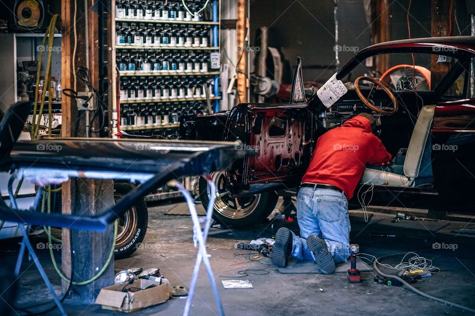 a worker work on a rusty car