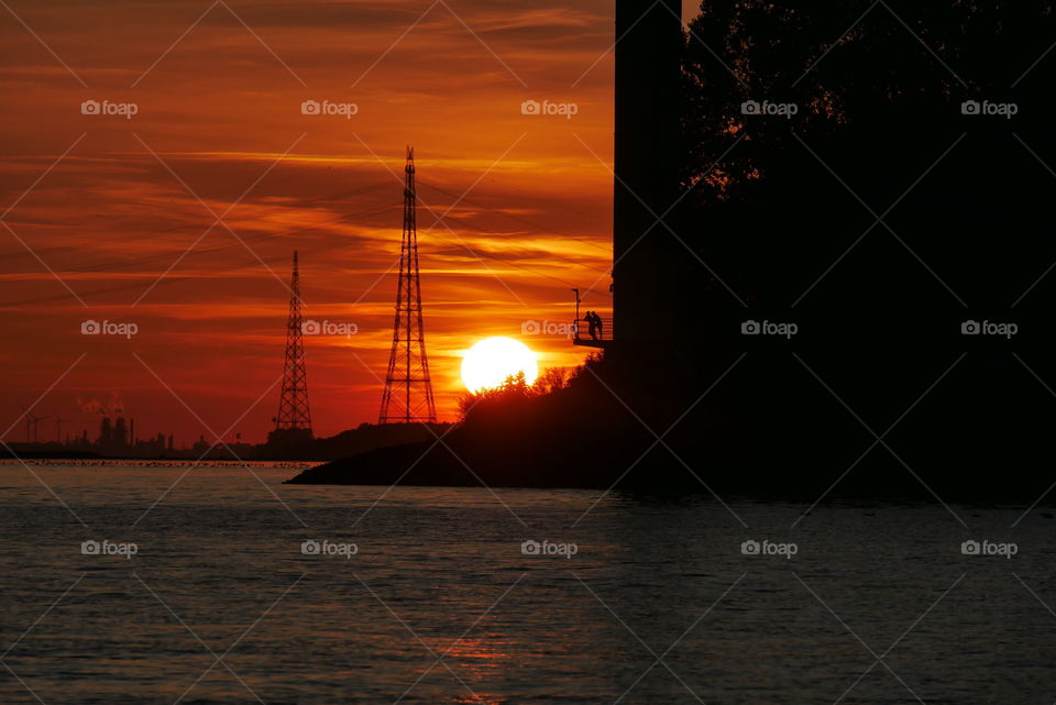 Sunset - on the river Elbe in Schleswig Holstein Germany - Two people enjoy the beautiful sunset from the platform of a tower