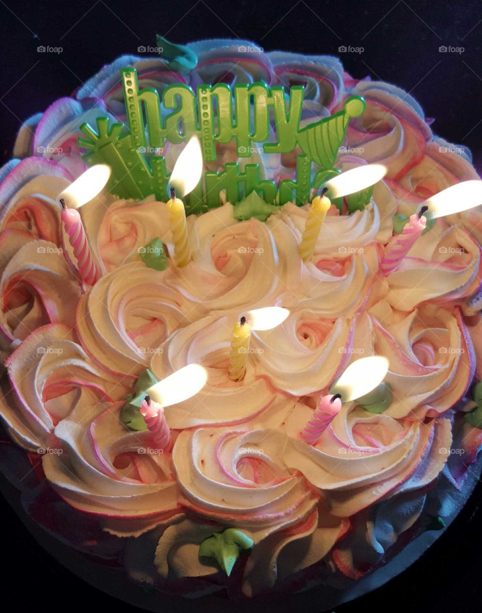 Skillfully frosted cake, with candles ablaze, helps to celebrate a very happy birthday.