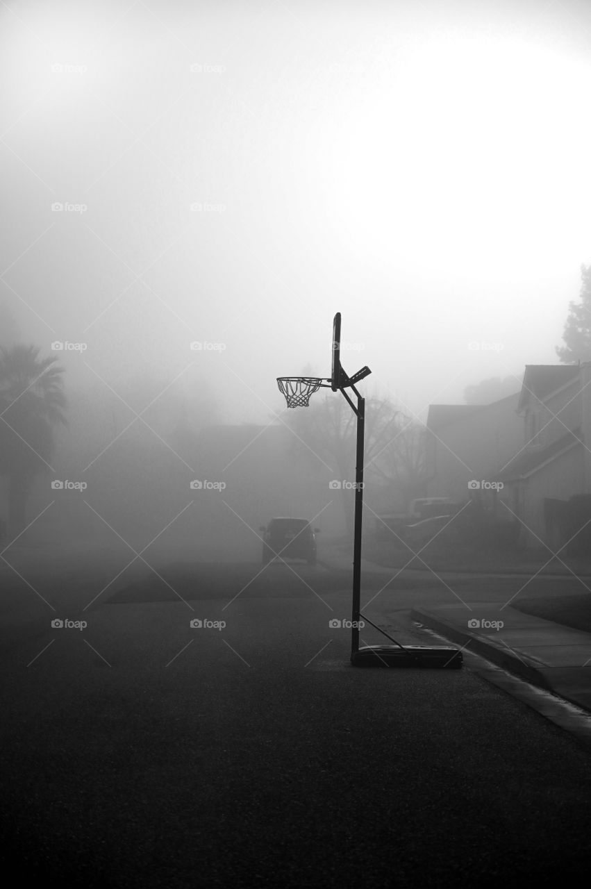 The lonely basketball hoop covered with the fog on our street one foggy morning of Waterford City. 
