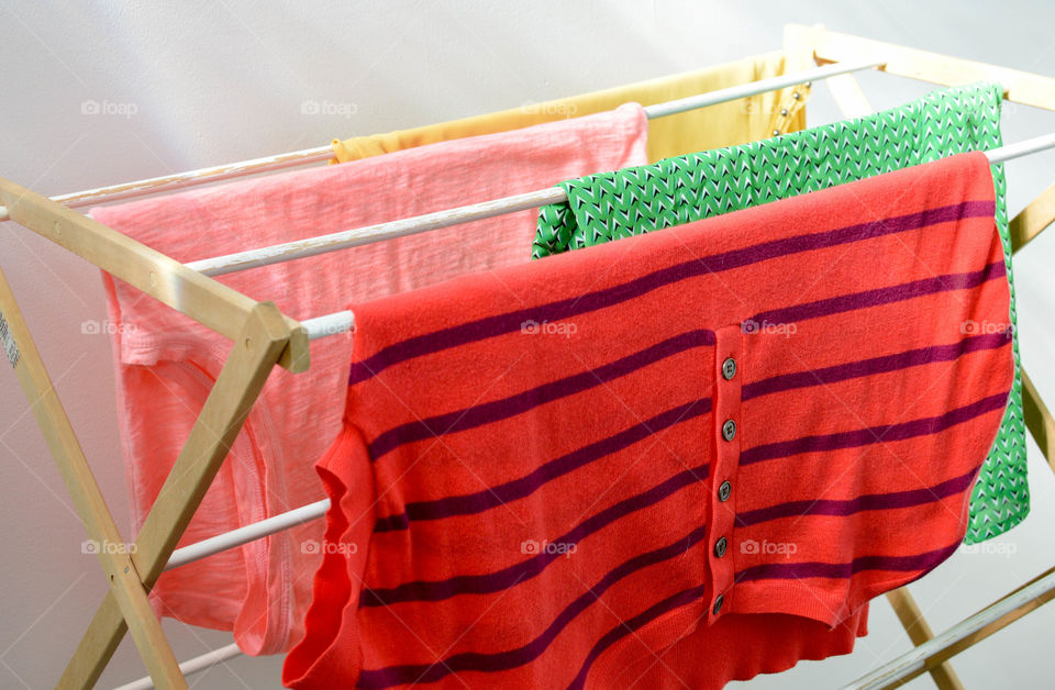 Colorful shirts hanging on a clothes rack to dry