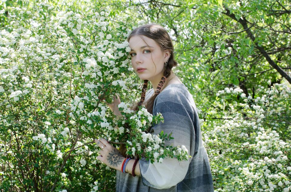 Portrait of Young Girl on Background of Flowers