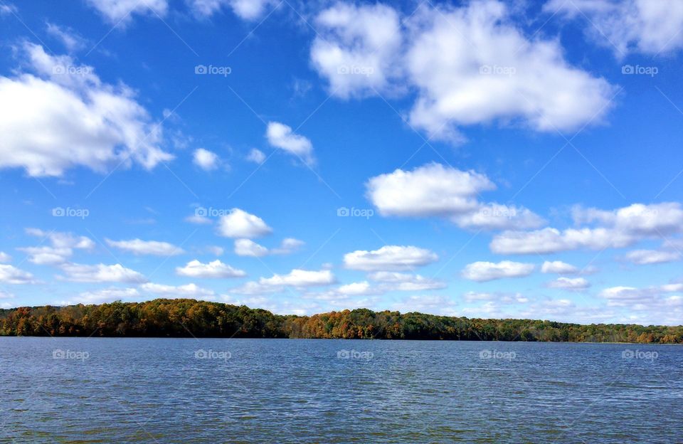 Beautiful autumn colors coming out on the leaves of trees around a picturesque lake on a sunny fall day 