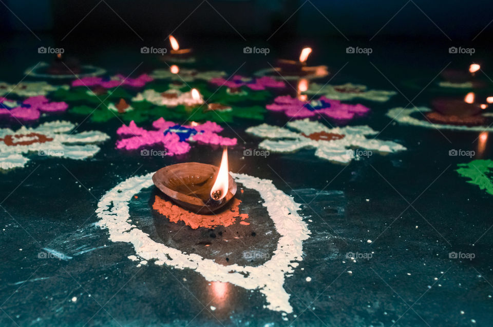 Diya Oil lamp in Rangoli decoration in Diwali festival. Concept of removing darkness.