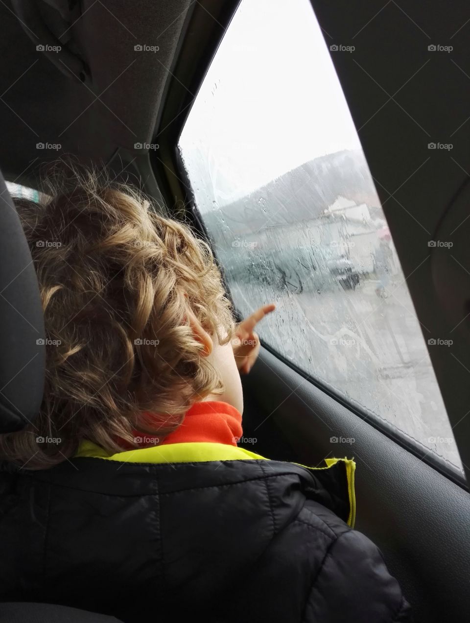 a kid drawing on a cars window