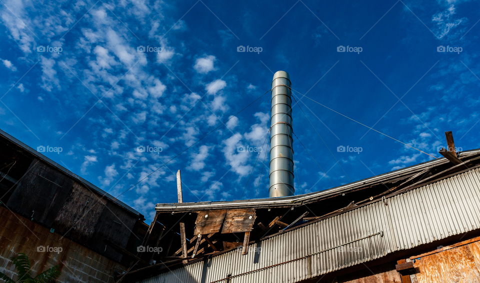 Roof of abandoned building with tall chimney 