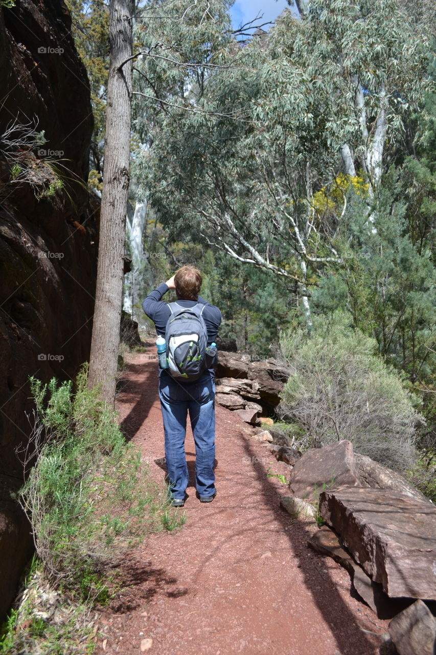 Male backpacker stopping to take a photo along mountain trail in south Australia 