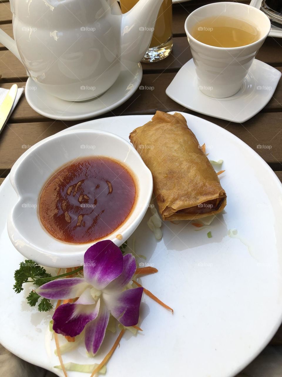 Spring roll with spicy red sauce and a purple orchid as decoration, Chinese food, Asian food, Cantonese dim sum 