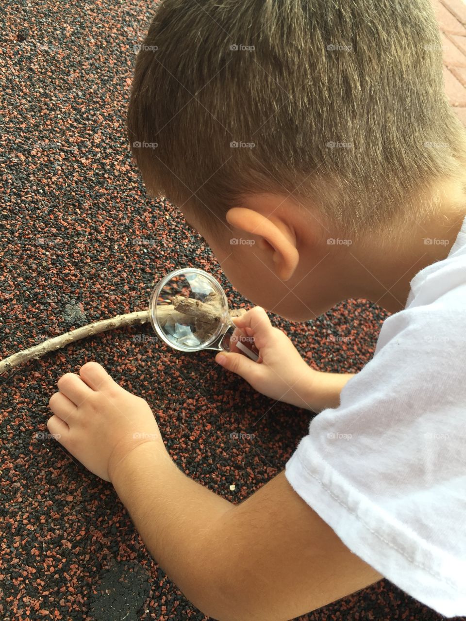 A kid look at magnifying glass