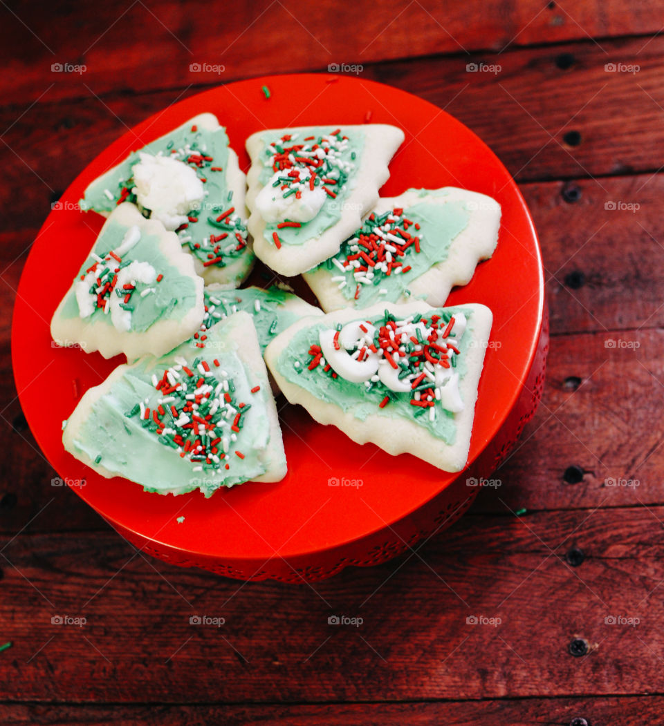 Hand decorated Christmas tree sugar cookies on a cake stand 