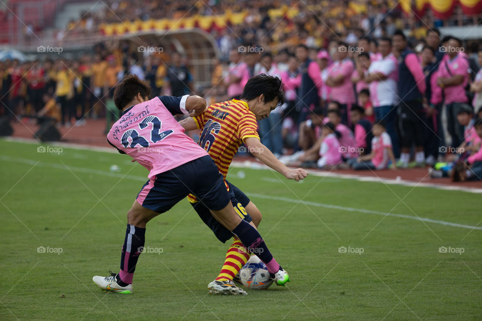 Football player fighting for the ball in the field 