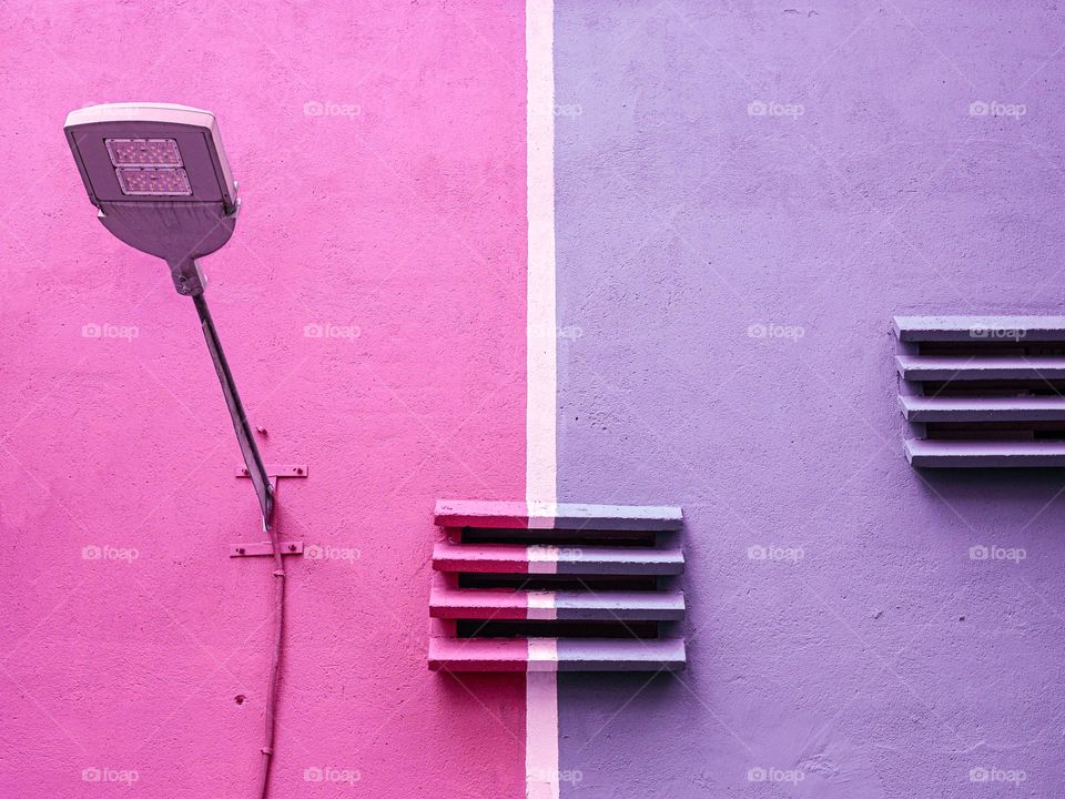 White line separating a pink and purple wall on a building