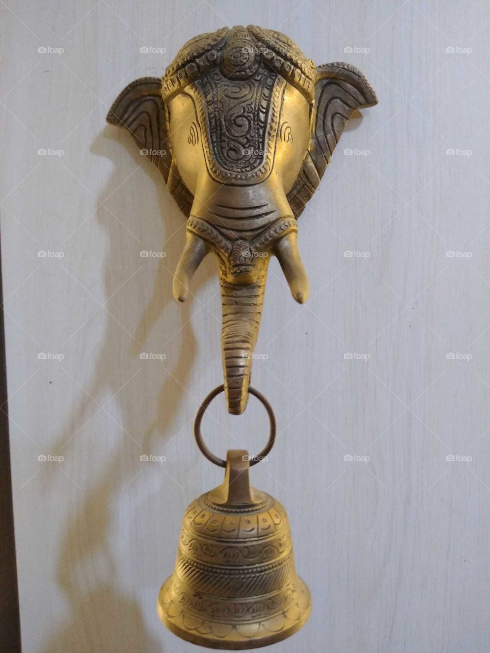 a brass elephant bell on the wall