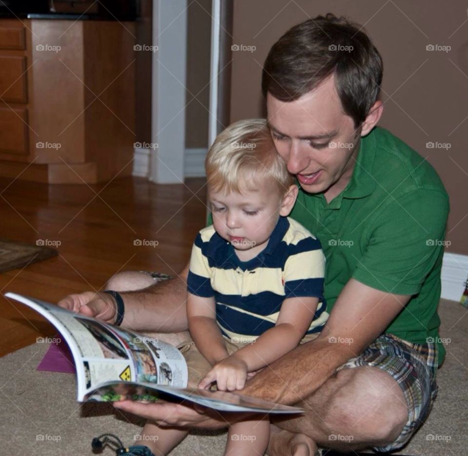 Father and son. Father reading book to son , family get together.