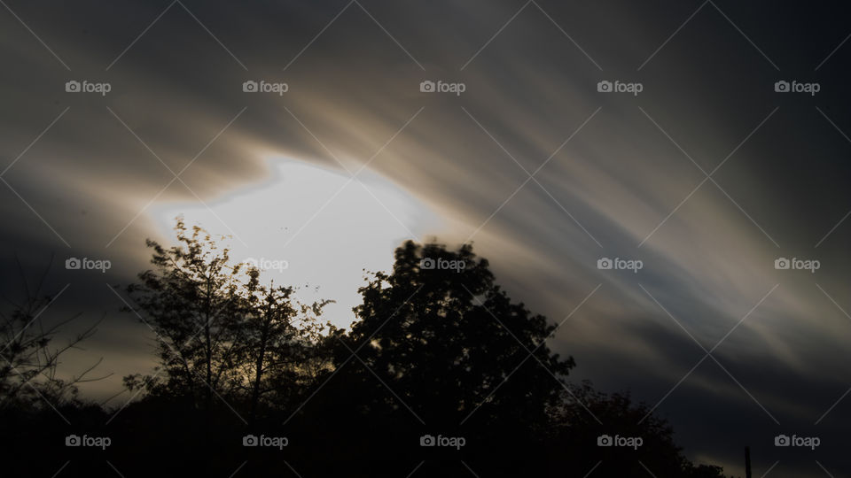 long exposure photo of whispy clouds across an autumn sky