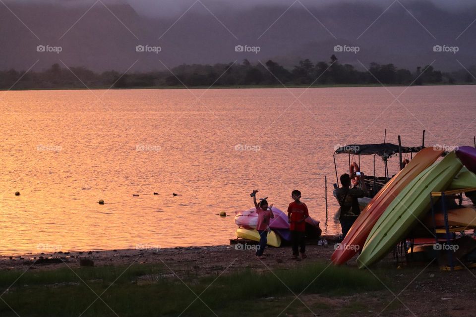 Kayaking activities with colourful kayak by the lake at  golden sunset