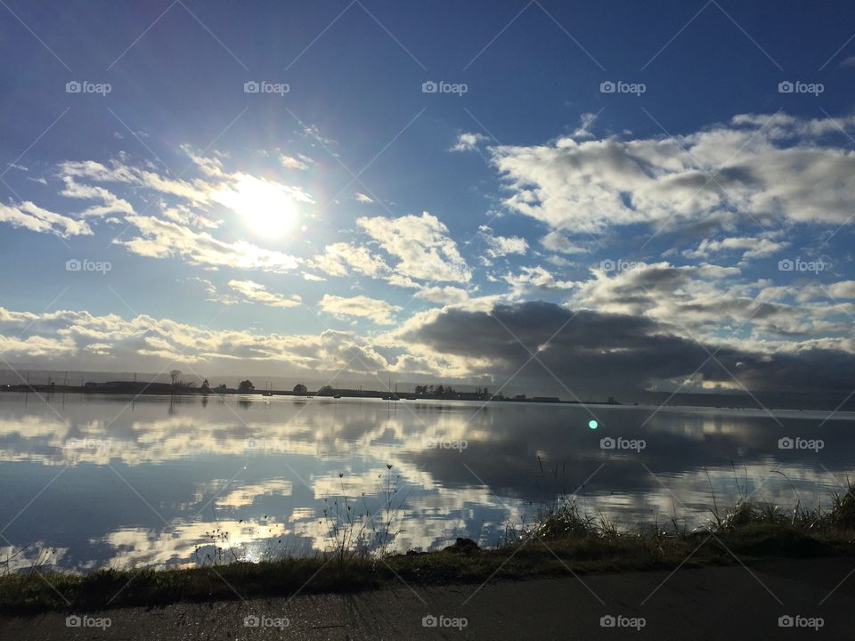 Mirrored clouds shine in the calm ocean water in this beautiful harbour on the West Coast. 