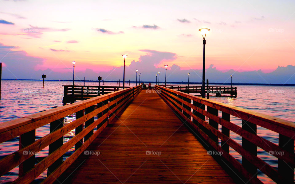 View of pier with light lamp during sunset