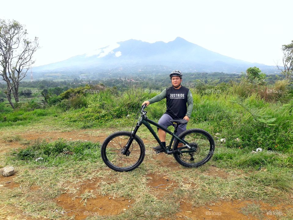 A man with his bicycle hardtail enduro against nature background, Indonesia Bike Park
