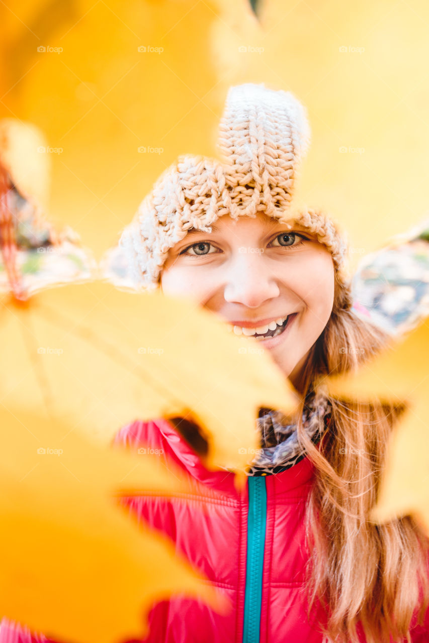Portrait of a smiling girl in autumn leaf