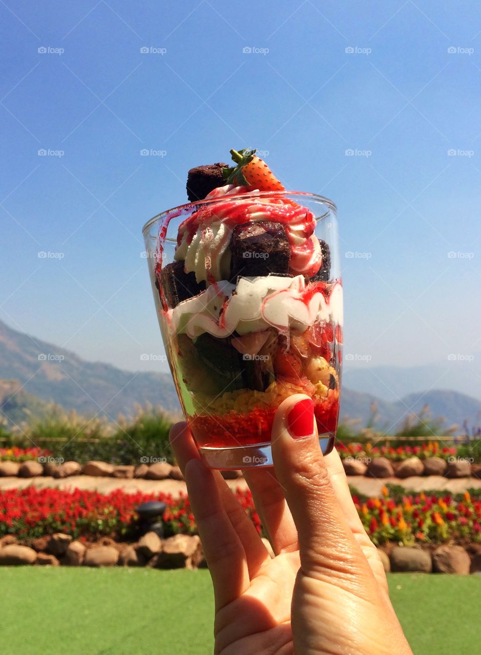 Hand holding colorful sweet in glass