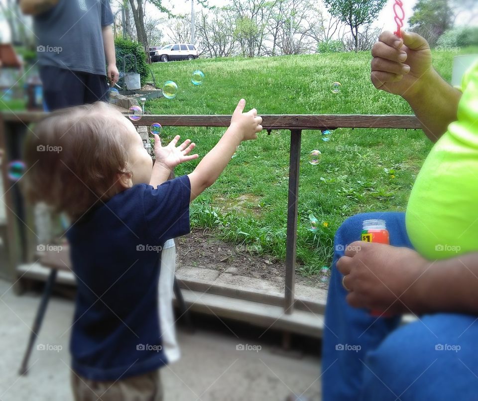 child playing with bubbles